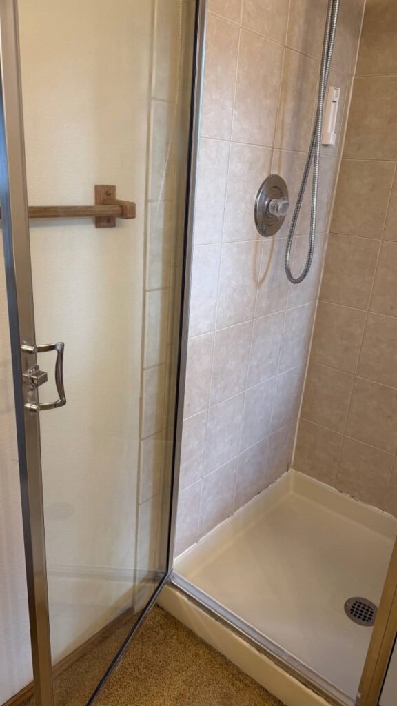Same shower door with clear glass and a clean white shower pan after JenyClean move-out cleaning in Bellevue, WA