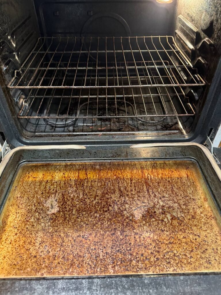 Oven interior with baked-on grease crust on the floor before JenyClean deep cleaning in Bothell, WA