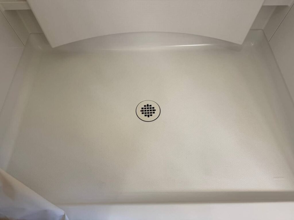 Clean white textured shower pan after JenyClean bathroom deep cleaning in Bothell, WA