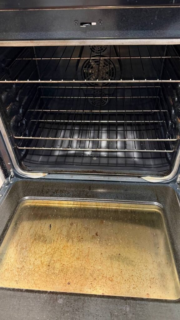 Open oven with a greasy, brown-stained door glass and dull racks before JenyClean move-out cleaning in Issaquah, WA