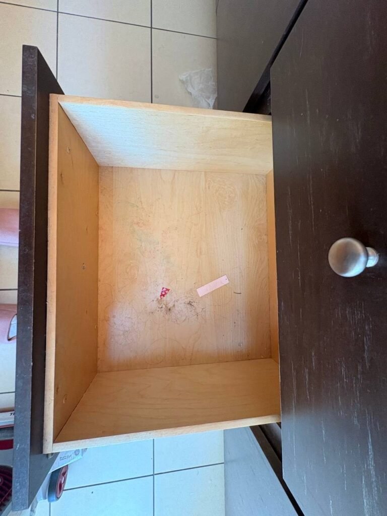 Open bathroom vanity drawer with dust, hair and debris inside before JenyClean post-remodel deep cleaning in Issaquah, WA