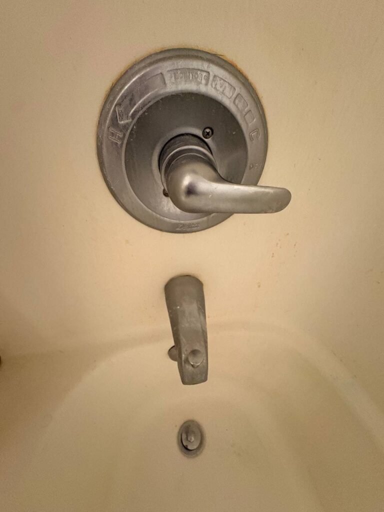 Tub faucet and valve trim dulled by white limescale before JenyClean standard cleaning in Issaquah, WA