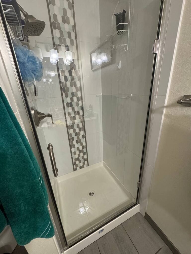 Same shower door with clear glass, sharp mosaic tile and a glossy white shower pan after JenyClean deep cleaning in Issaquah, WA