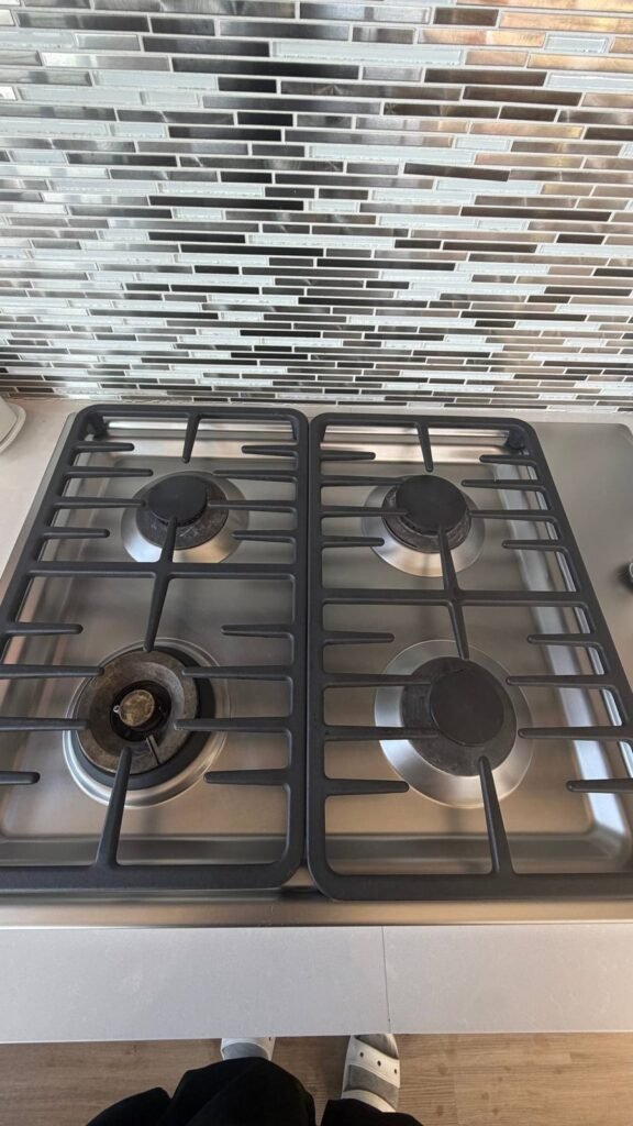 Clean stainless steel gas cooktop with degreased cast-iron grates and polished surface after JenyClean cleaning in Kirkland, WA