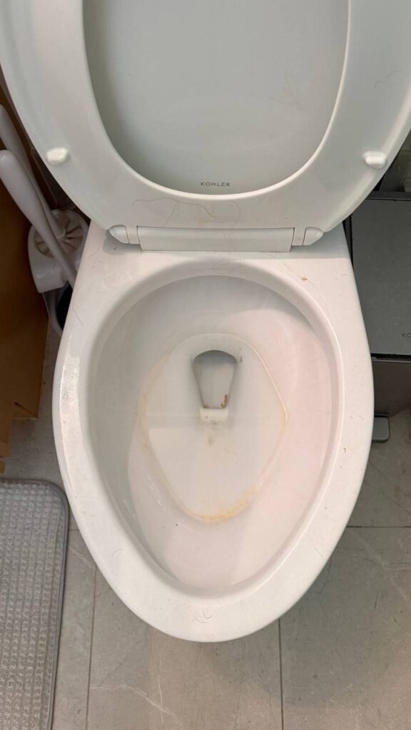 Toilet bowl with an orange waterline ring and stains before JenyClean deep cleaning in Kirkland, WA