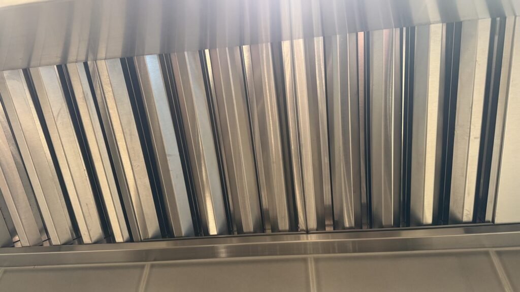 Clean silver baffle filters back in the range hood after JenyClean kitchen deep cleaning in Redmond, WA
