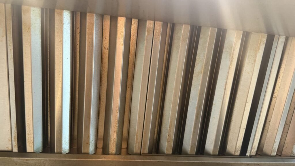 Range hood baffle filters coated with yellow grease before JenyClean kitchen deep cleaning in Redmond, WA