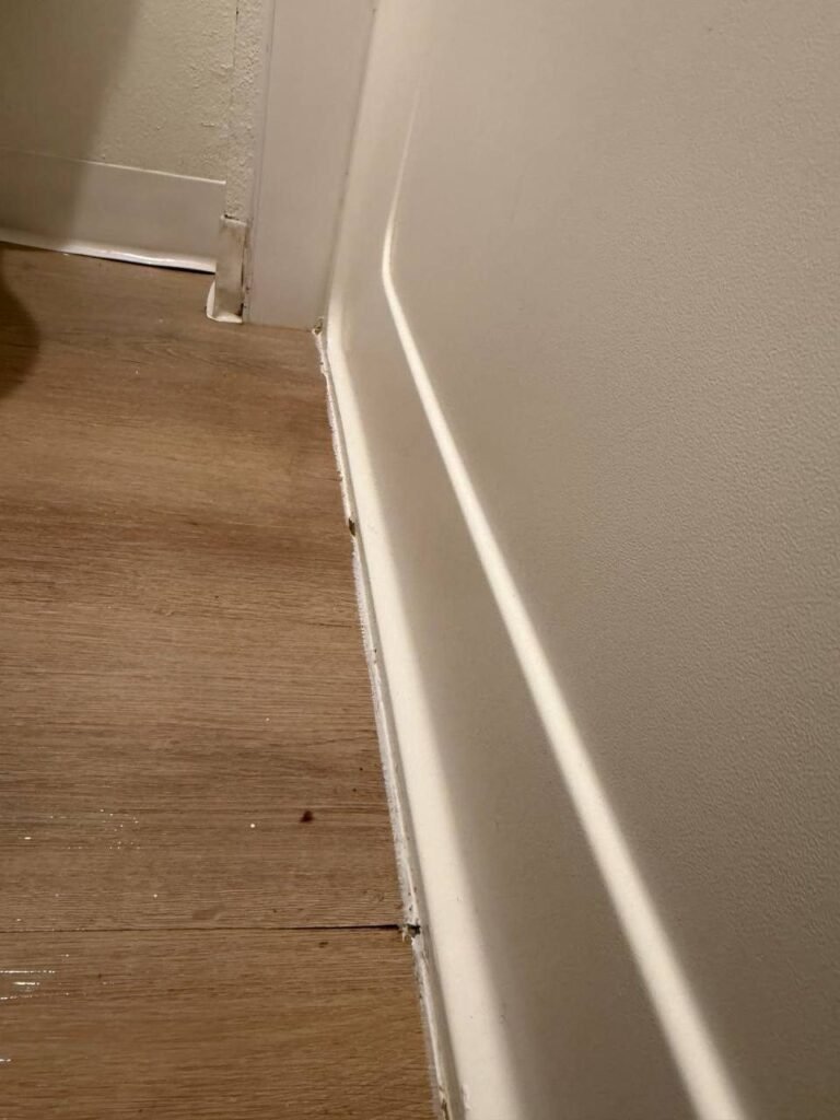 Clean baseboard and floor edge along the bathtub after JenyClean same-day cleaning in Renton, WA