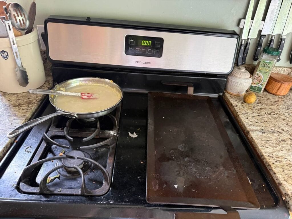 Gas stove with a used skillet and a griddle pan with food residue before JenyClean cleaning in Seattle, WA