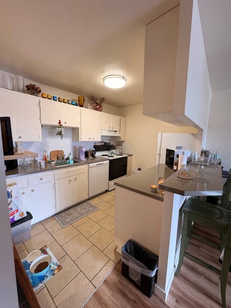 Kitchen with clear counters, empty floor and tidy bar counter after JenyClean cleaning and organizing in Seattle, WA