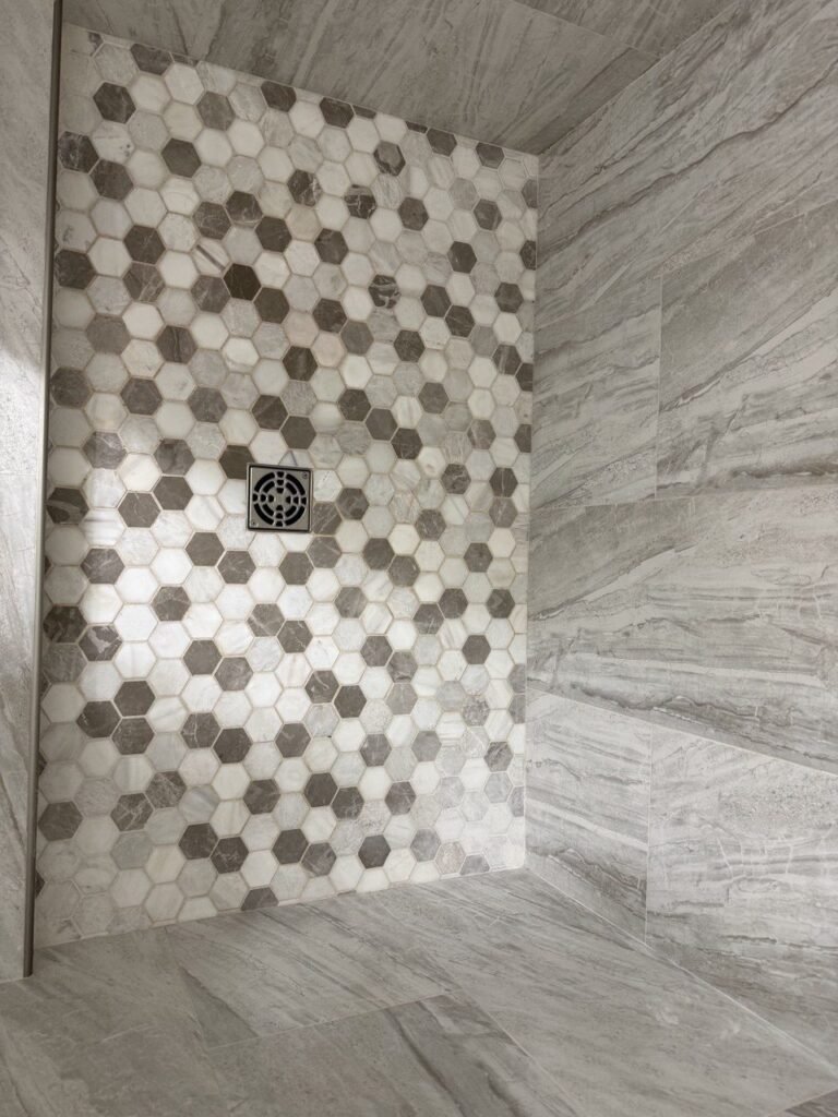 Hexagon mosaic shower floor with lighter, cleaned grout after JenyClean deep cleaning in Seattle, WA
