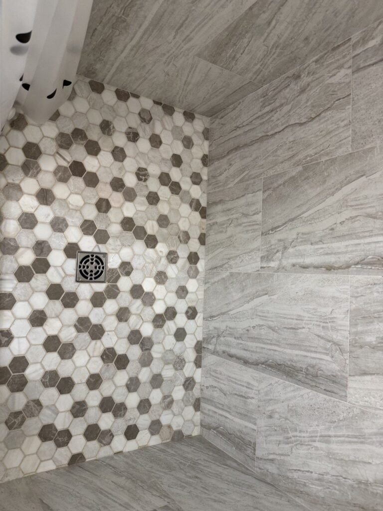 Hexagon mosaic shower floor with darkened grout lines before JenyClean deep cleaning in Seattle, WA