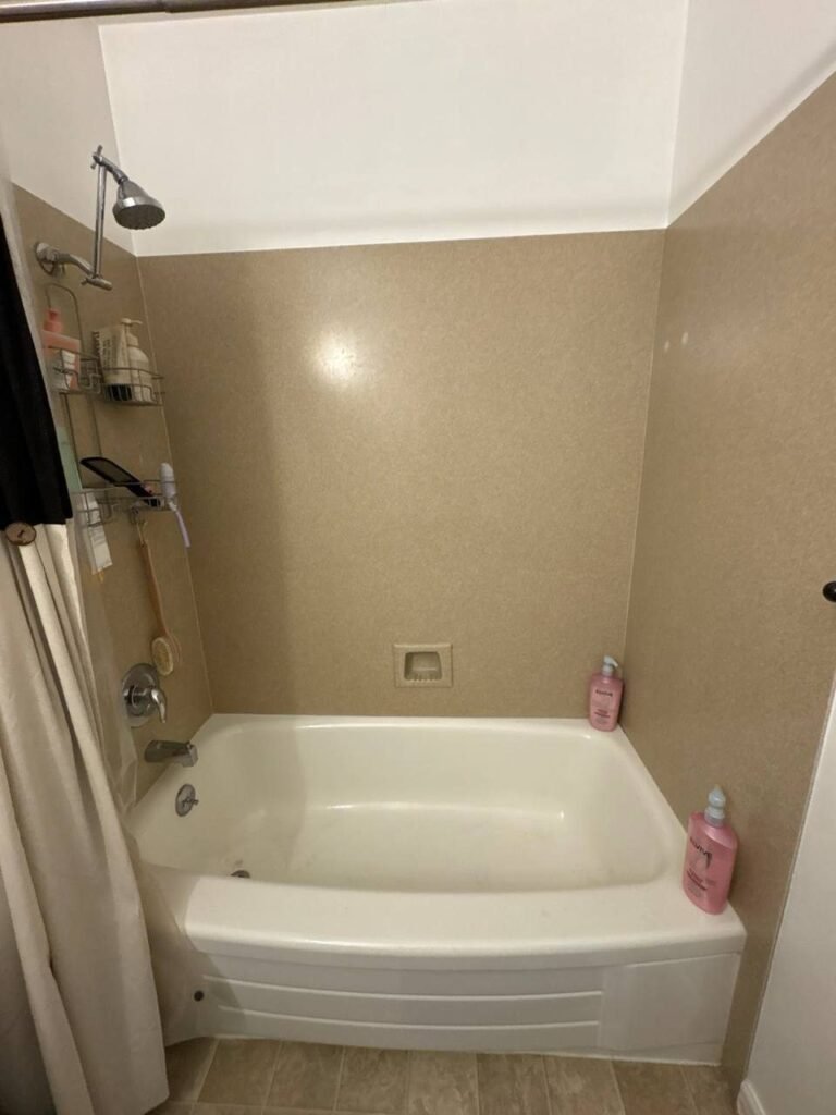 Bathtub with a gray film of soap residue and grime on the floor of the tub before JenyClean deep cleaning in Seattle, WA