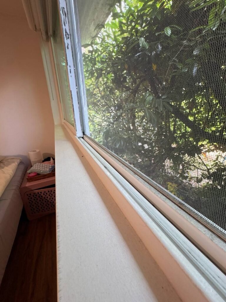 Bedroom window track packed with gray dust along the screen frame before JenyClean deep cleaning in Seattle, WA