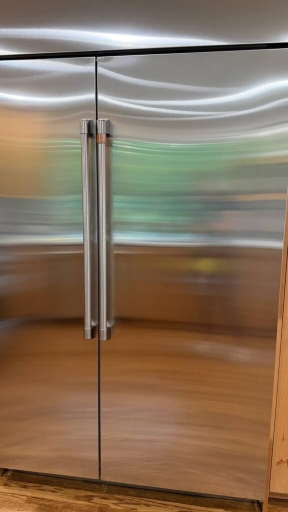 Clean stainless fridge handles and door edges after JenyClean regular cleaning in Seattle, WA