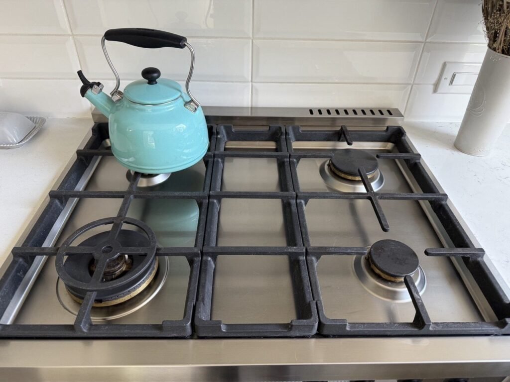 Clean stainless gas cooktop with grates back in place after JenyClean deep cleaning in Seattle, WA