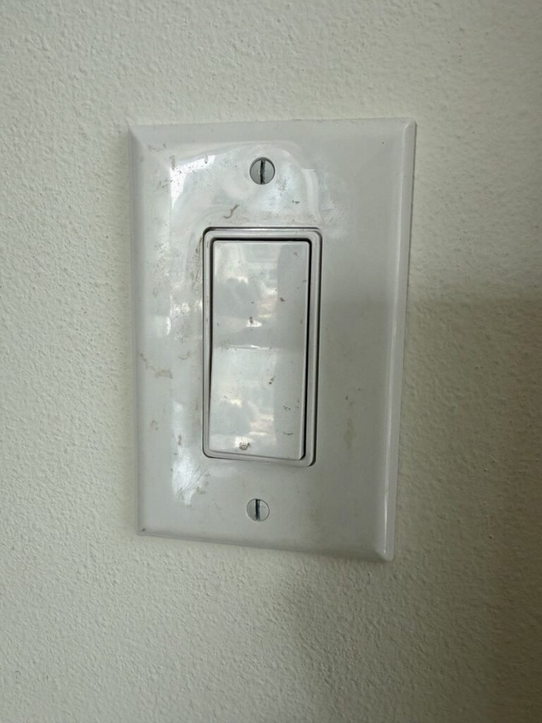 White light switch plate with fingerprints and smudges before JenyClean urgent deep cleaning in Seattle, WA
