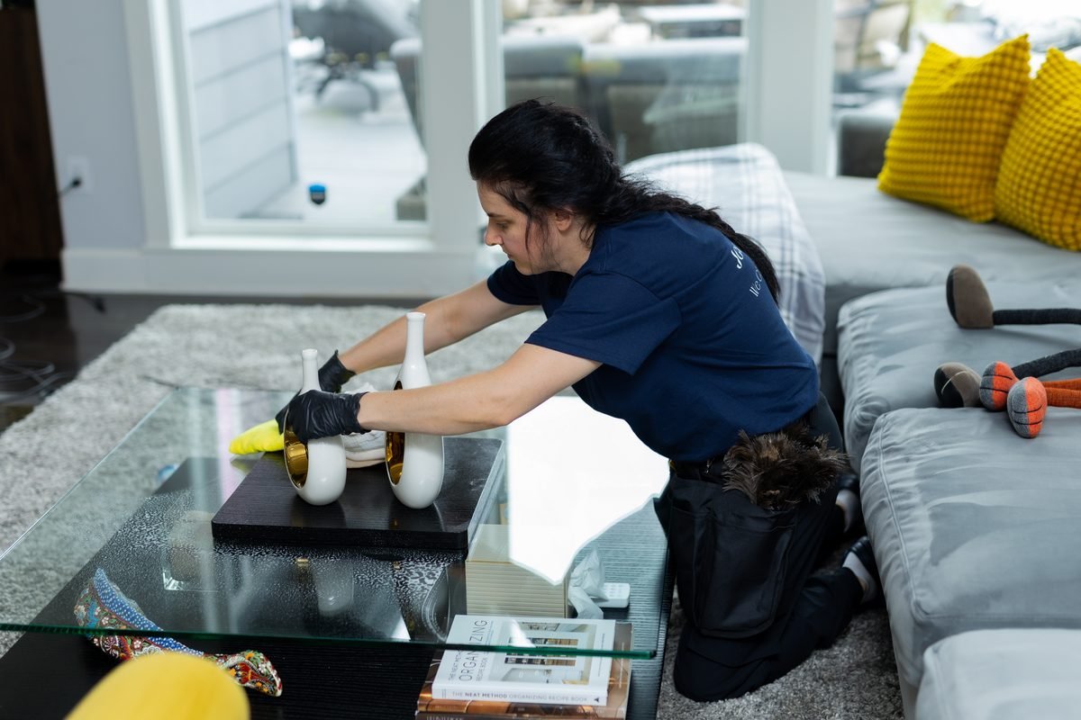 House cleaning in Kirkland: JenyClean cleaner wiping a glass coffee table in a living room