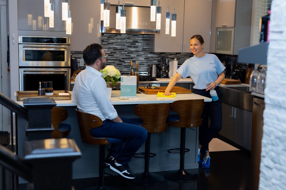 House cleaning in Bellevue: JenyClean cleaner wiping a kitchen island while the homeowner sits at the counter