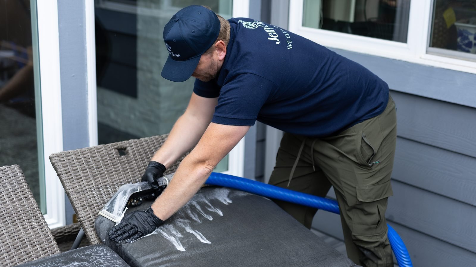 JenyClean technician extracting dirt from an outdoor chaise cushion